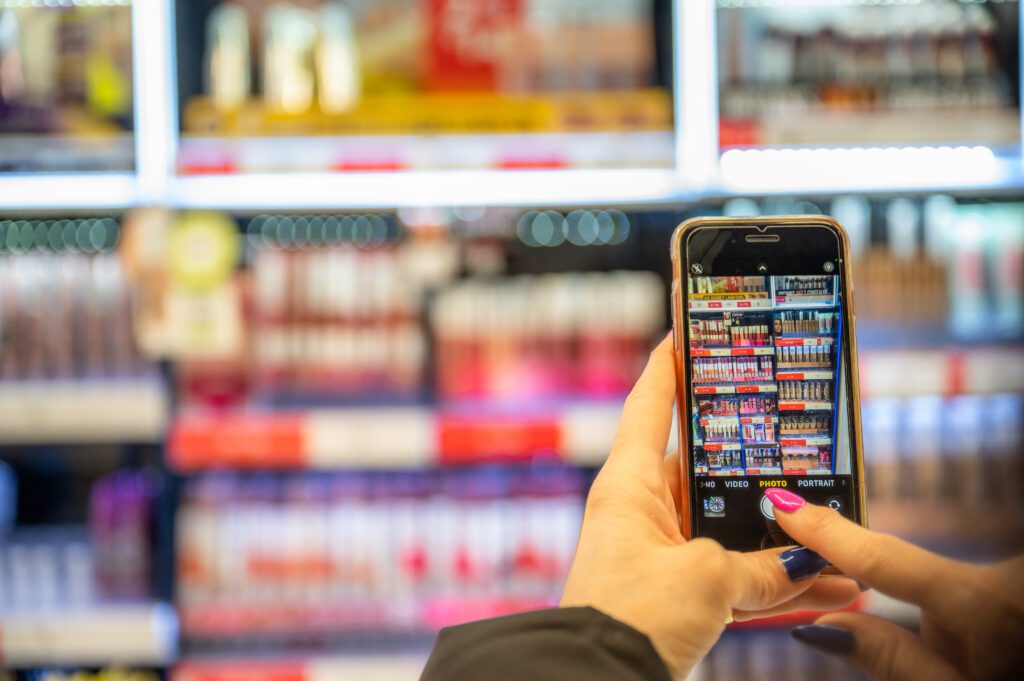 woman taking a picture of cosmetics in a store