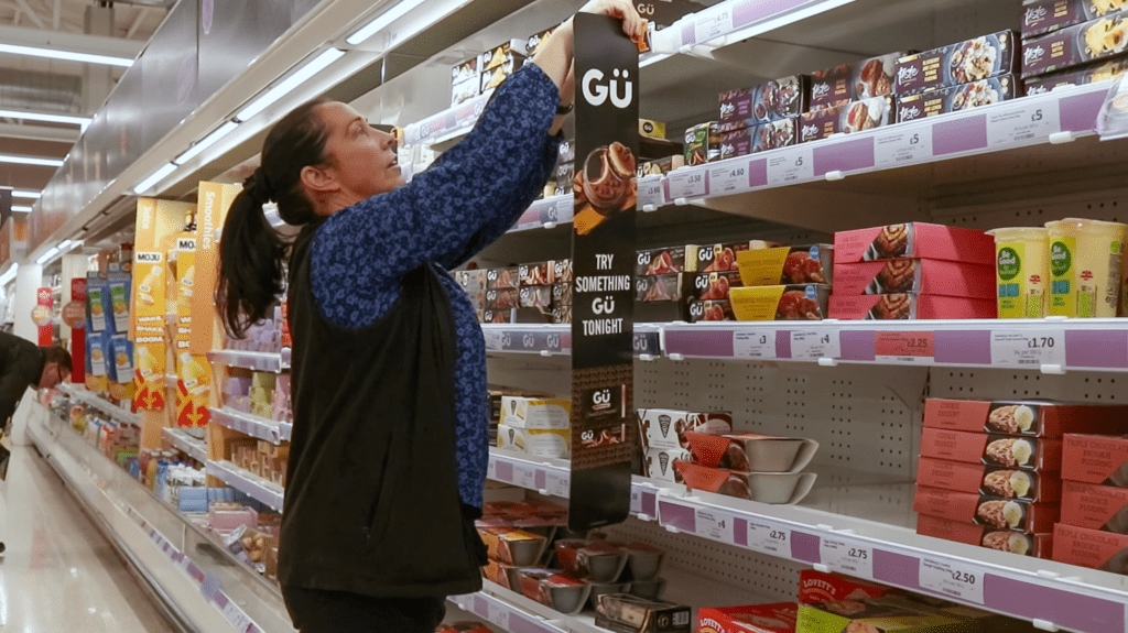 Worker loading supermarket shelves - Gu